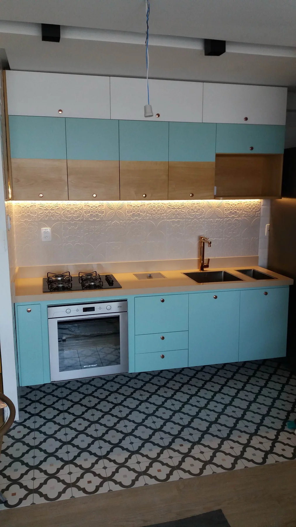 Cozinha planejada azul com bancada, armários superiores e iluminação linear