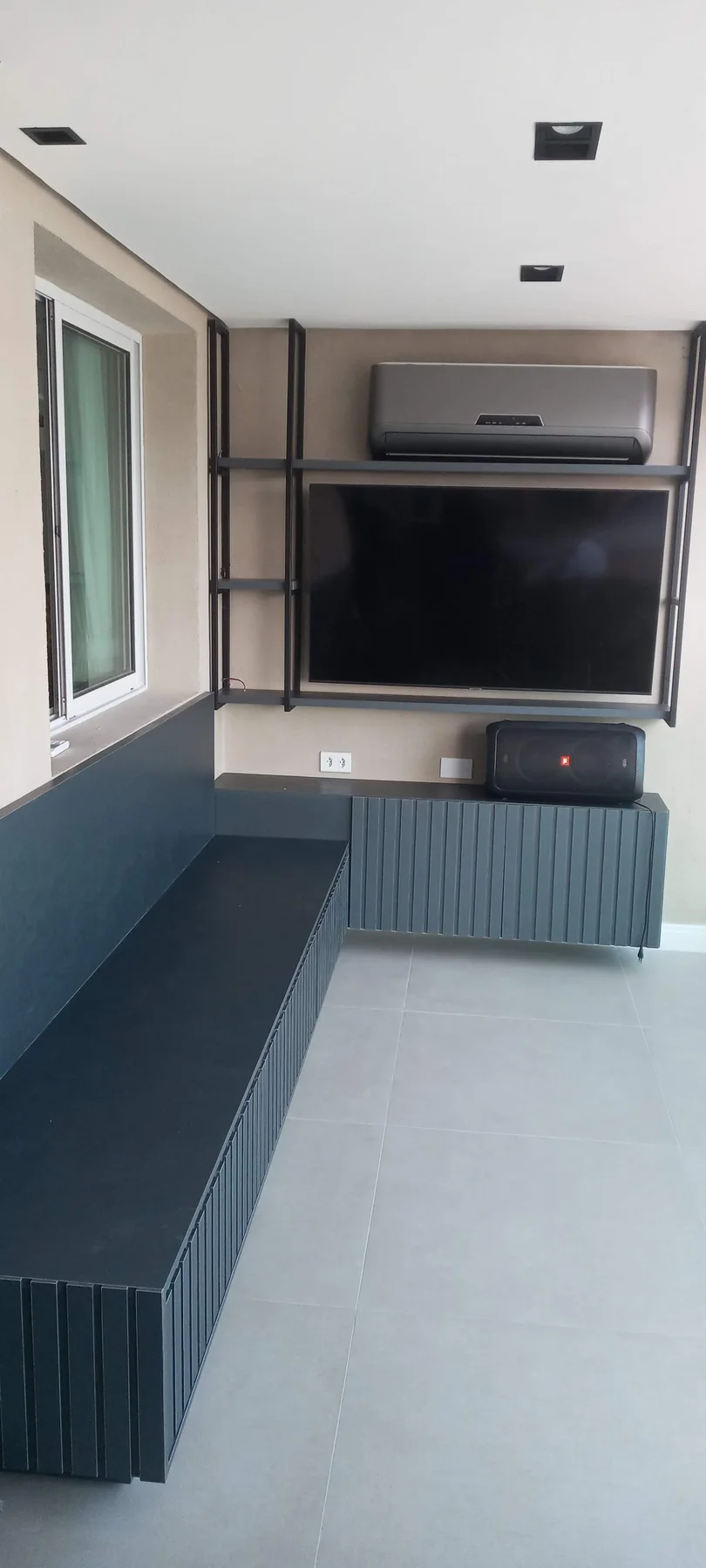 Painel escuro com televisão e estrutura metálica